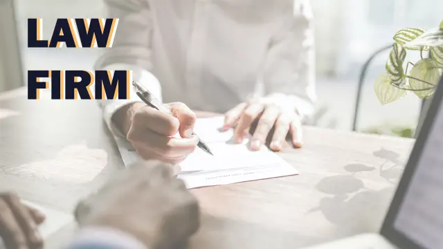Law Firm: a lawyer signing a document across a desk from a client