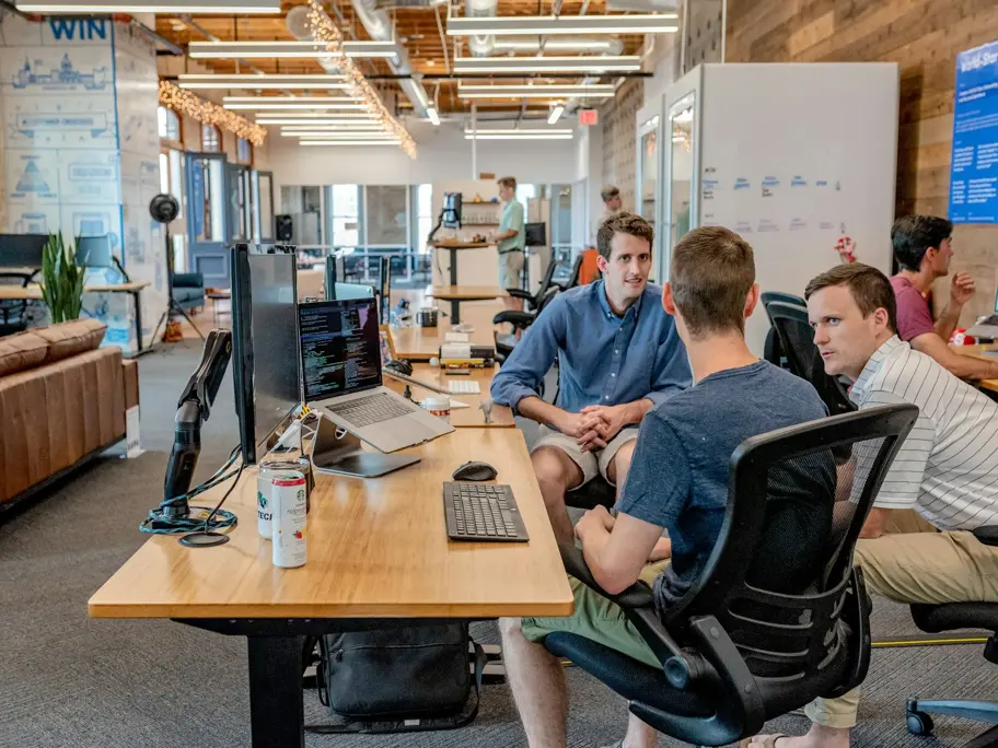 Three colleagues sitting together at a table in an office